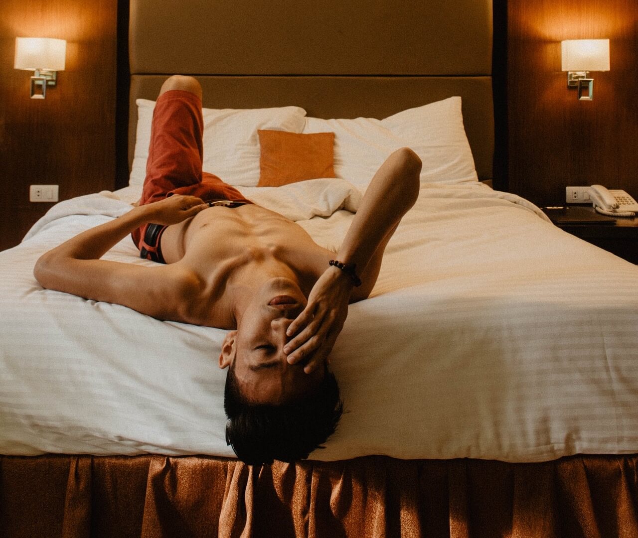 Shirtless man laying on back with closed eyes