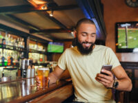 Man in bar looking at phone